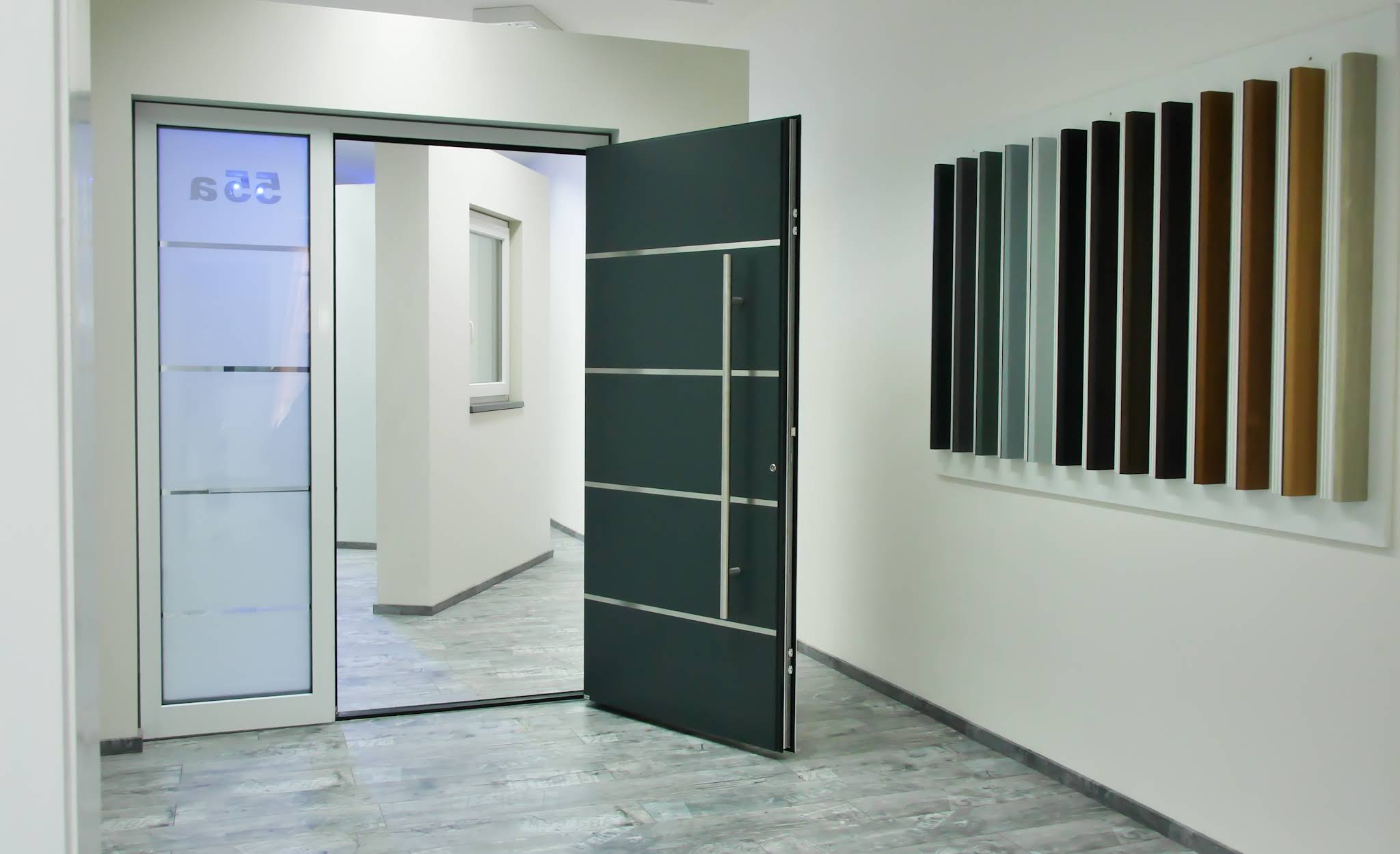 Geöffnete anthrazitfarbene Haustür im Schauraum von Schnell Fenster mit Farbmusterwand